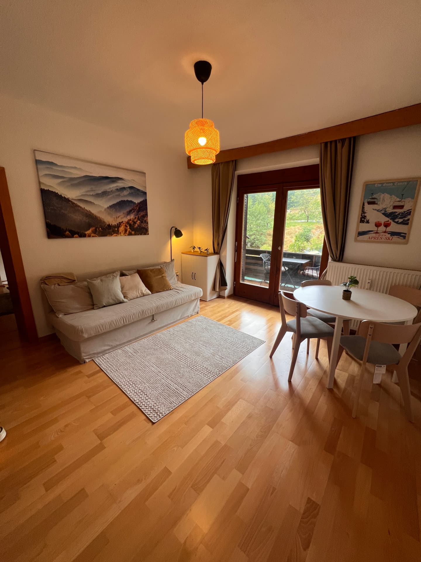 Bright living room of Trio Apartment with sofa bed, dining table and balcony door